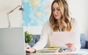 Travel agent working with flight documents at office.