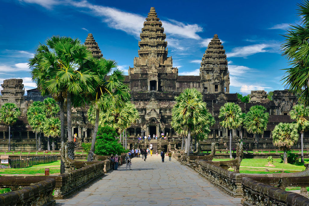 Travelers from Sky Bird Travel & Tours top travel destinations in 2023 walk along the path of Angkor Wat temple in Cambodia.